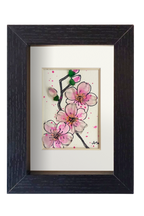 Cuadro con dibujo de rama de almendro con flores de tinta y acuarela con vidrio de mar resaltando los pétalos y los capullos