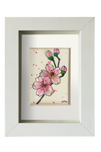 Cuadro con dibujo de rama de almendro con flores de tinta y acuarela con vidrio de mar resaltando los pétalos y los capullos