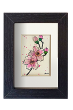 Cuadro con dibujo de rama de almendro con flores de tinta y acuarela con vidrio de mar resaltando los pétalos y los capullos