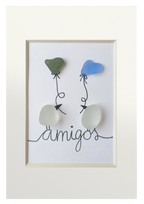 Cuadro de vidrio de mar y tinta en el que dos Pájaros posados encima del texto amigos se intercambian sedos globos con forma de corazón