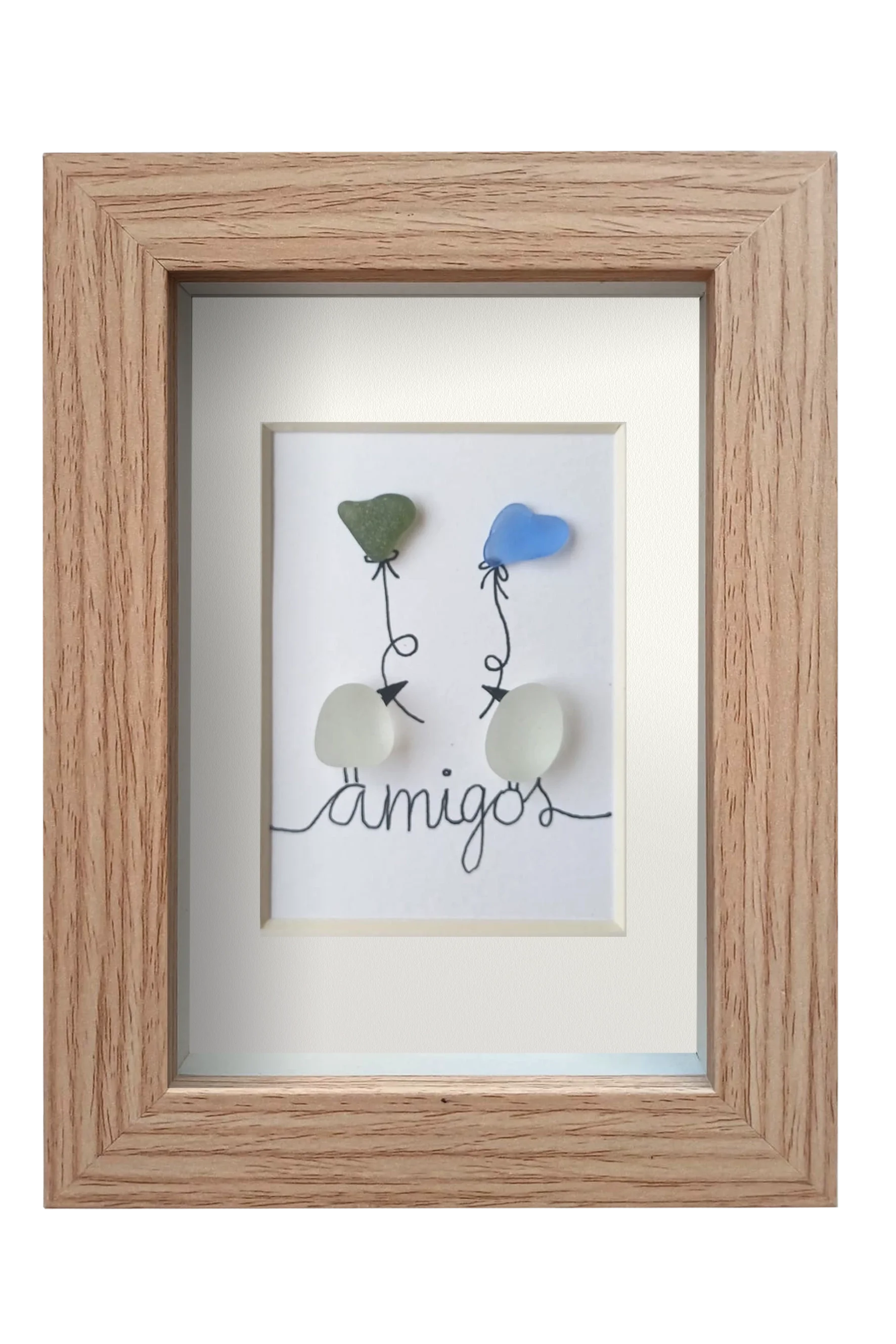 Cuadro de vidrio de mar y tinta en el que dos Pájaros posados encima del texto amigos se intercambian sedos globos con forma de corazón. Marco madera