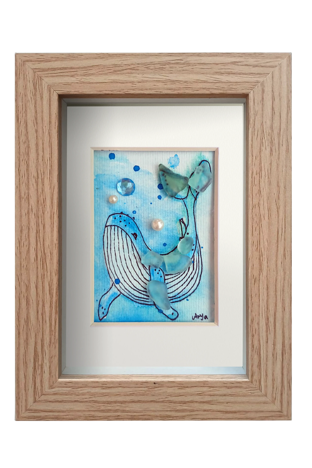 Cuadro con ilustración en acuarela y tinta de una ballena en el fondo del mar con vidrio y otros materiales dándo volumen y aportando fantasía