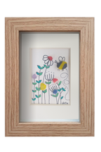 Cuadro de vidrio de mar sobre tinta y acuarela con un abejorro revoloteando entre flores silvestres de distintos colores. Marco madera