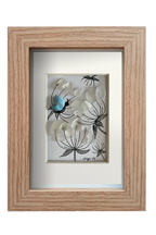 Cuadro con dibujo de flores blancas con los tallos con líneas de tinta y flores con vidrio de mar translúcido y una mariposa de alas azules 