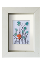 Cuadro con flores azules y una mariposa naranja hechos con tinta y vidrio de mar azlul para las flores y naranja para las alas de la mariposa