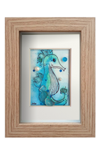 Cuadro con ilustración en acuarela y tinta de un caballito de mar en el fondo del oceano con vidrio y otros materiales dándo volumen y aportando fantasía