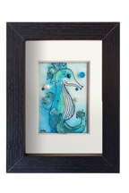 Cuadro con ilustración en acuarela y tinta de un caballito de mar en el fondo del oceano con vidrio y otros materiales dándo volumen y aportando fantasía