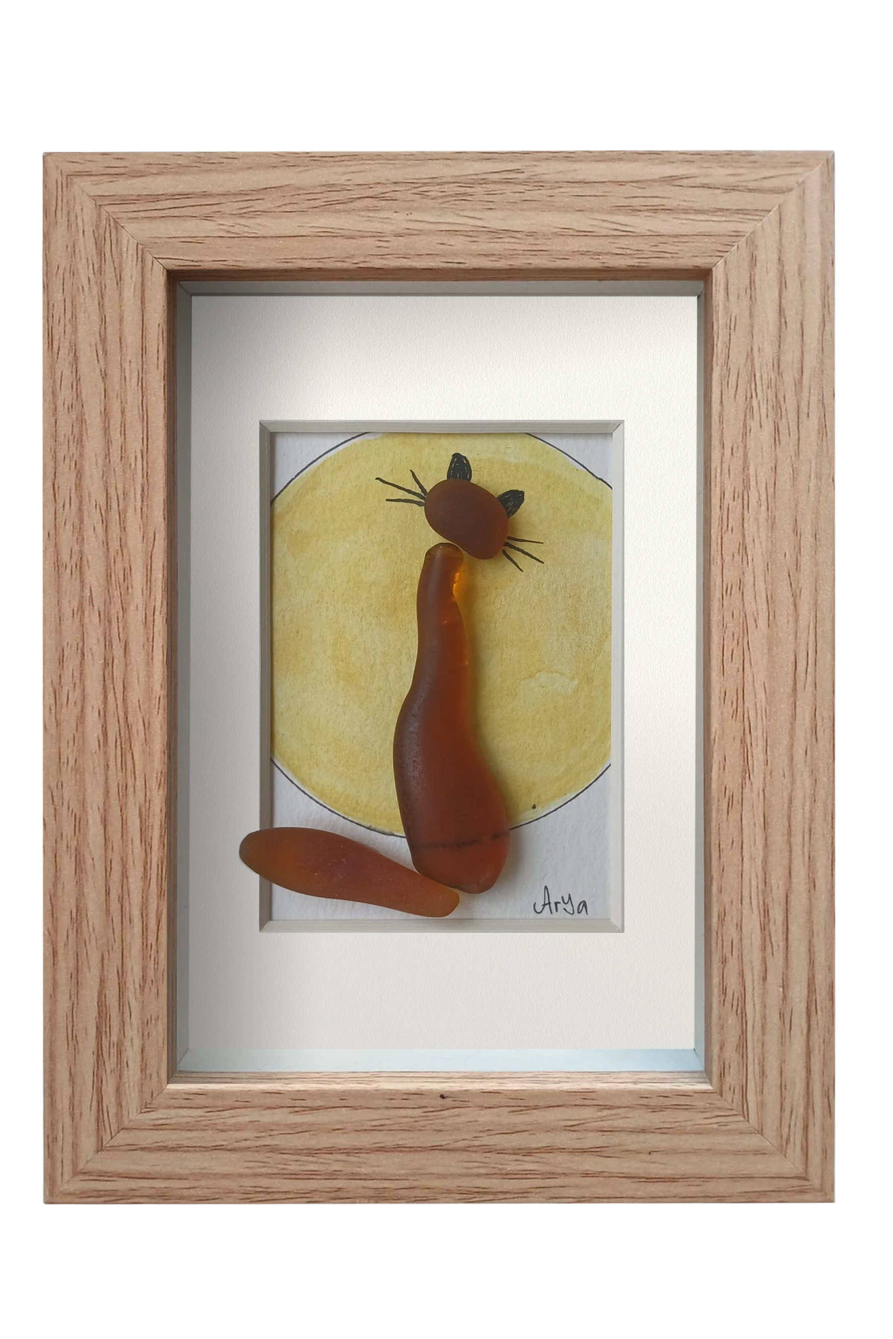 Cuadro con una luna amarilla de acuarela y tinta con un gato hecho con vidrio de mar marrón enfrente contemplándola. Marco madera