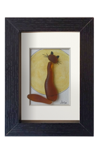 Cuadro con una luna amarilla de acuarela y tinta con un gato hecho con vidrio de mar marrón enfrente contemplándola. Marco negro