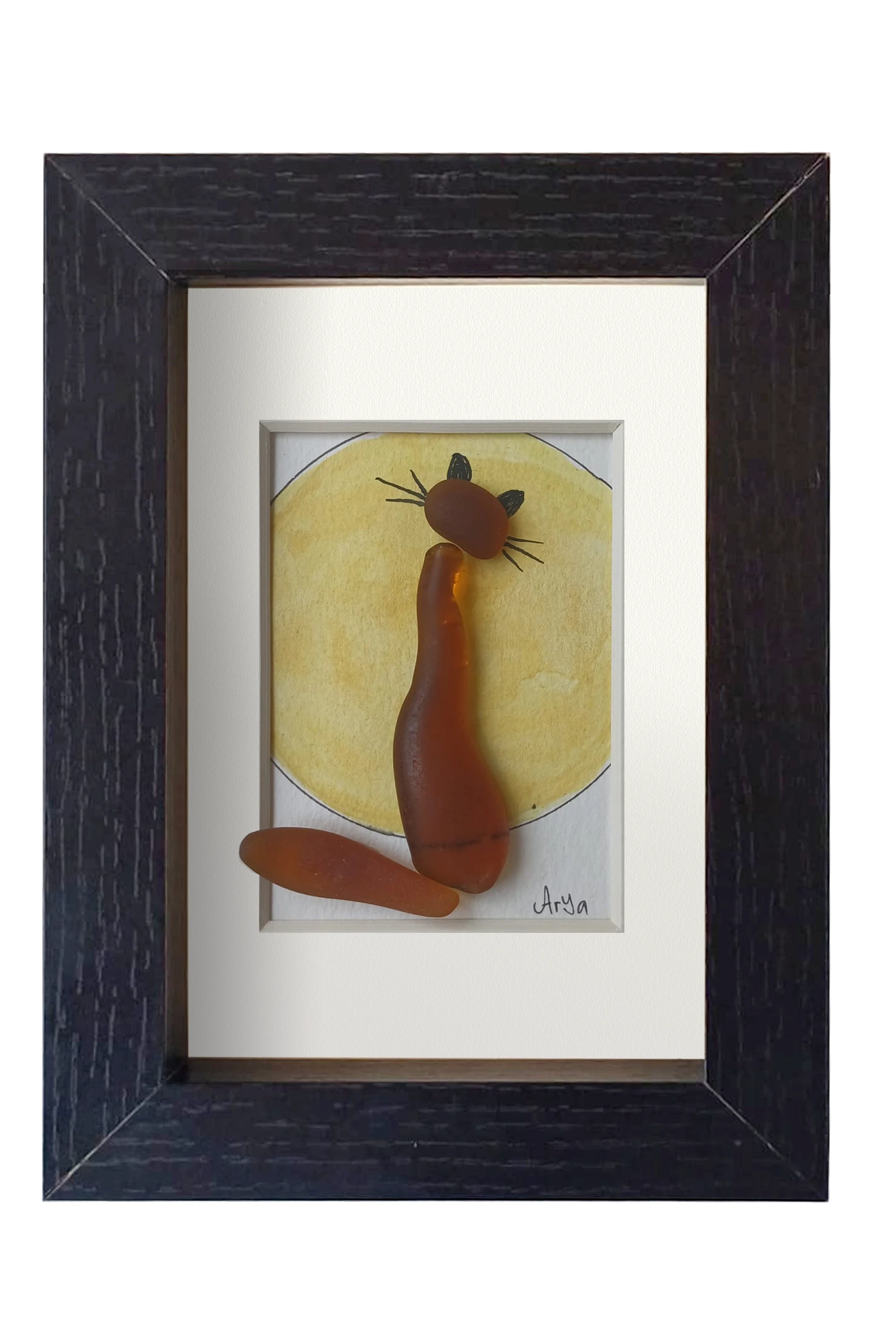 Cuadro con una luna amarilla de acuarela y tinta con un gato hecho con vidrio de mar marrón enfrente contemplándola. Marco negro