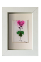 Cuadro con dibujo de chica con falda de vidrio de mar verde que sostiene sobre la cabeza una flor de loto rosada hecha con acuarela y tinta. Marco blanco