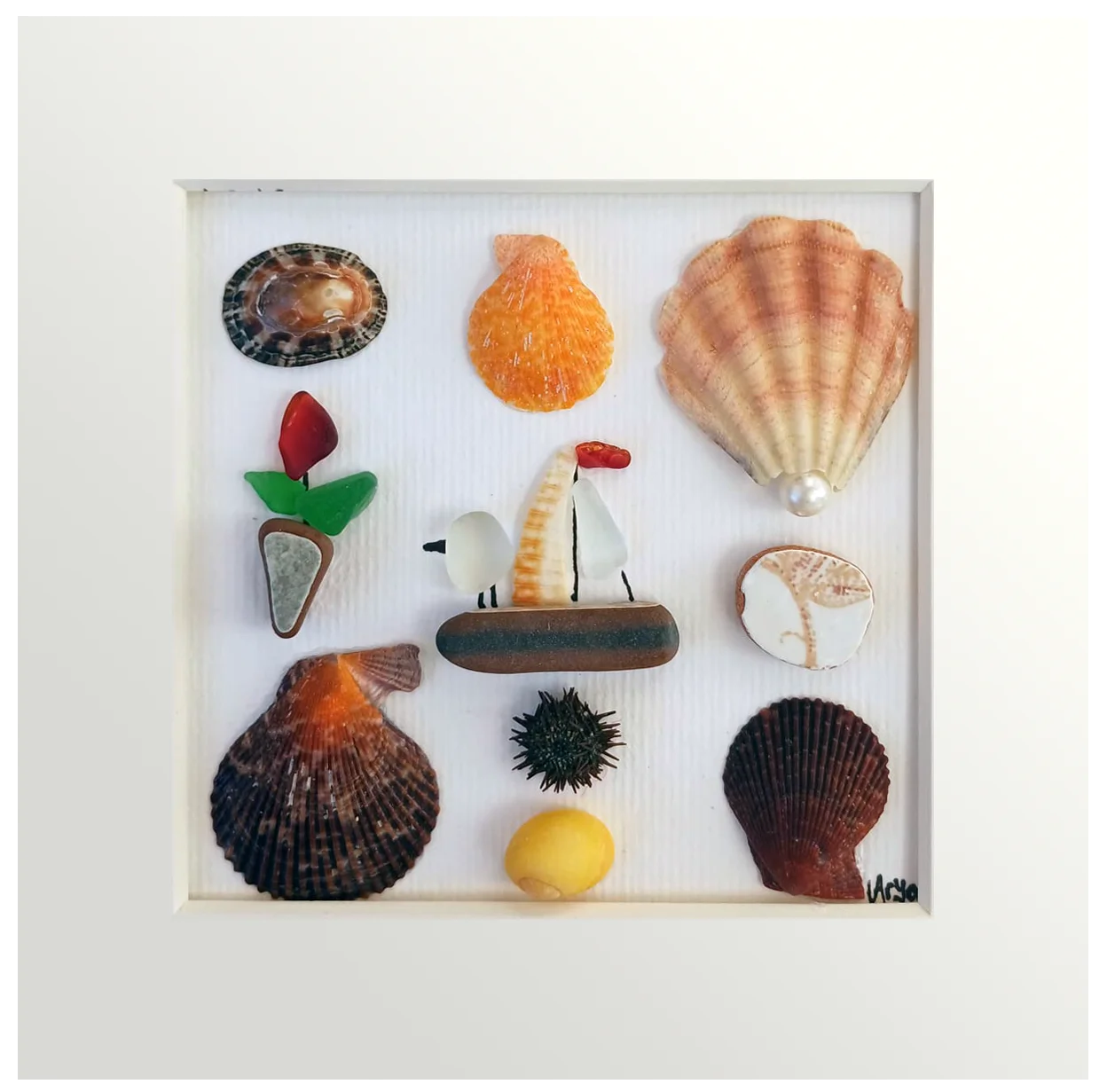Cuadro con conchas mediterránas y un barquito de cerámica con un pajaro dentro acercándose a una flor roja de vidrio de mar