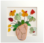 Cuadro con un fragmento de cerámica desgastado a modo de maceta y una explosión de hojas y flores multicolor hechas con tinta y vidrio de mar 