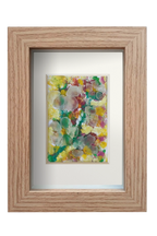 Cuadro de collage con temperas y vidrio de mar translúcido con una representación floral muy colorida. Marco color madera