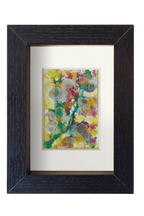 Cuadro de collage con temperas y vidrio de mar translúcido con una representación floral muy colorida. Marco negro