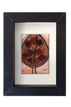 Cuadro de tinta, acuarela y vidrio de mar marrón representando una hoja otoñal. Marco negro