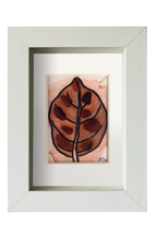 Cuadro de tinta, acuarela y vidrio de mar marrón representando una hoja otoñal. Marco blanco