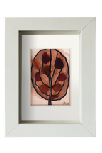 Cuadro de tinta, acuarela y vidrio de mar marrón representando una hoja otoñal. Marco blanco