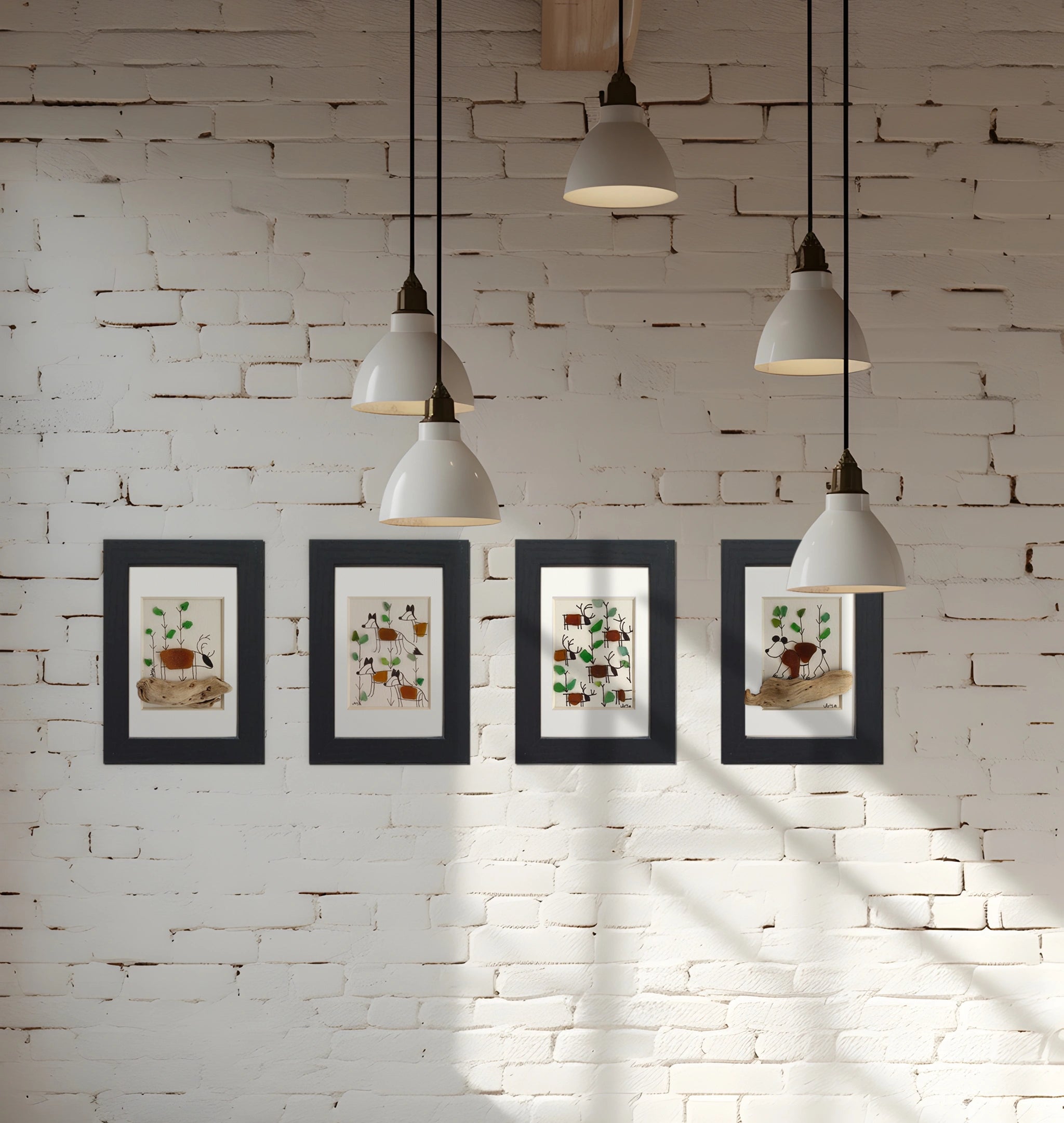 Pared de ladrillo pintada de blanco con 4 cuadros con motivos nórdicos y lámparas de lineas simples blancas colgando del techo