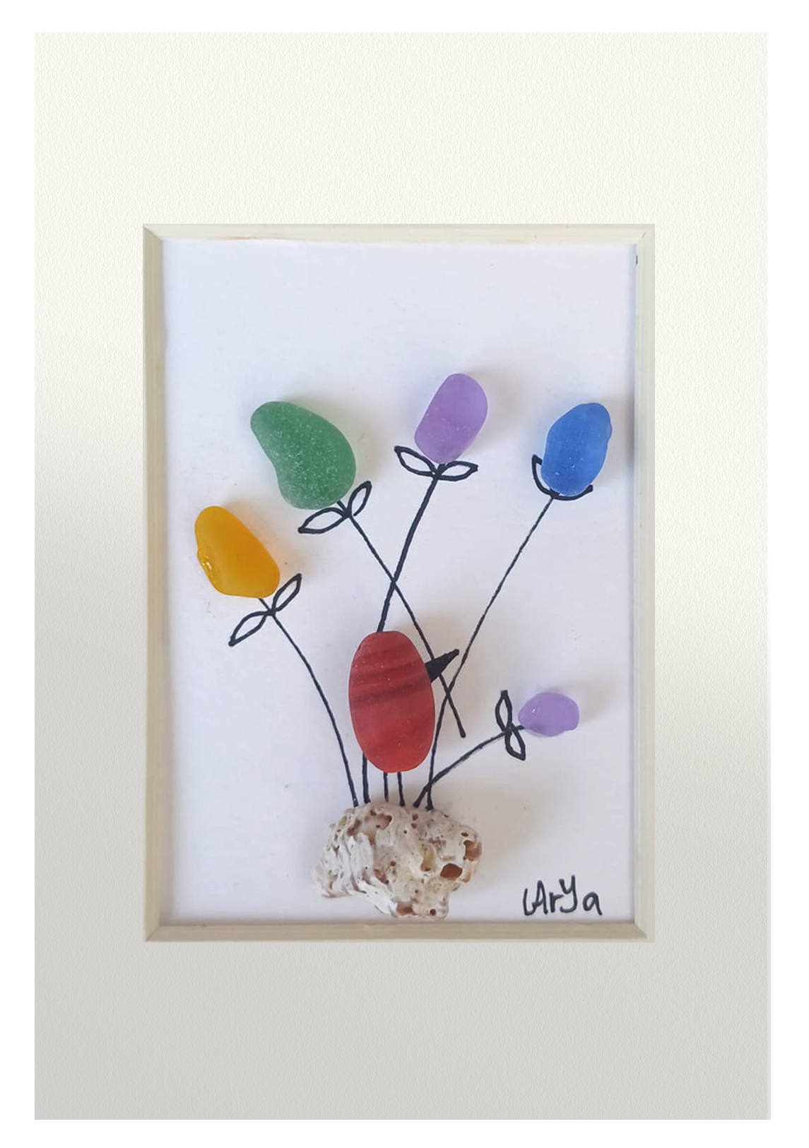 Simpático pajarito de cristal de mar pulido rojo entre flores de varios colores