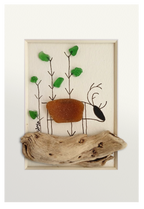 Cuadro con un fragmento de madera desgastado a modo de camino y un reno dibujado en tinta y vidrio de mar marrón, andando por un bosque adornado con vidrios verdes. 