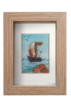 Cuadro con velero de vidrio de mar y fragmentos de conchas navegando en un mar celeste de acuarela que se entrelaza con el cielo limpio con unas gaviotas volando. Pájaro mena el barco mirando al horizonte. Marco madera