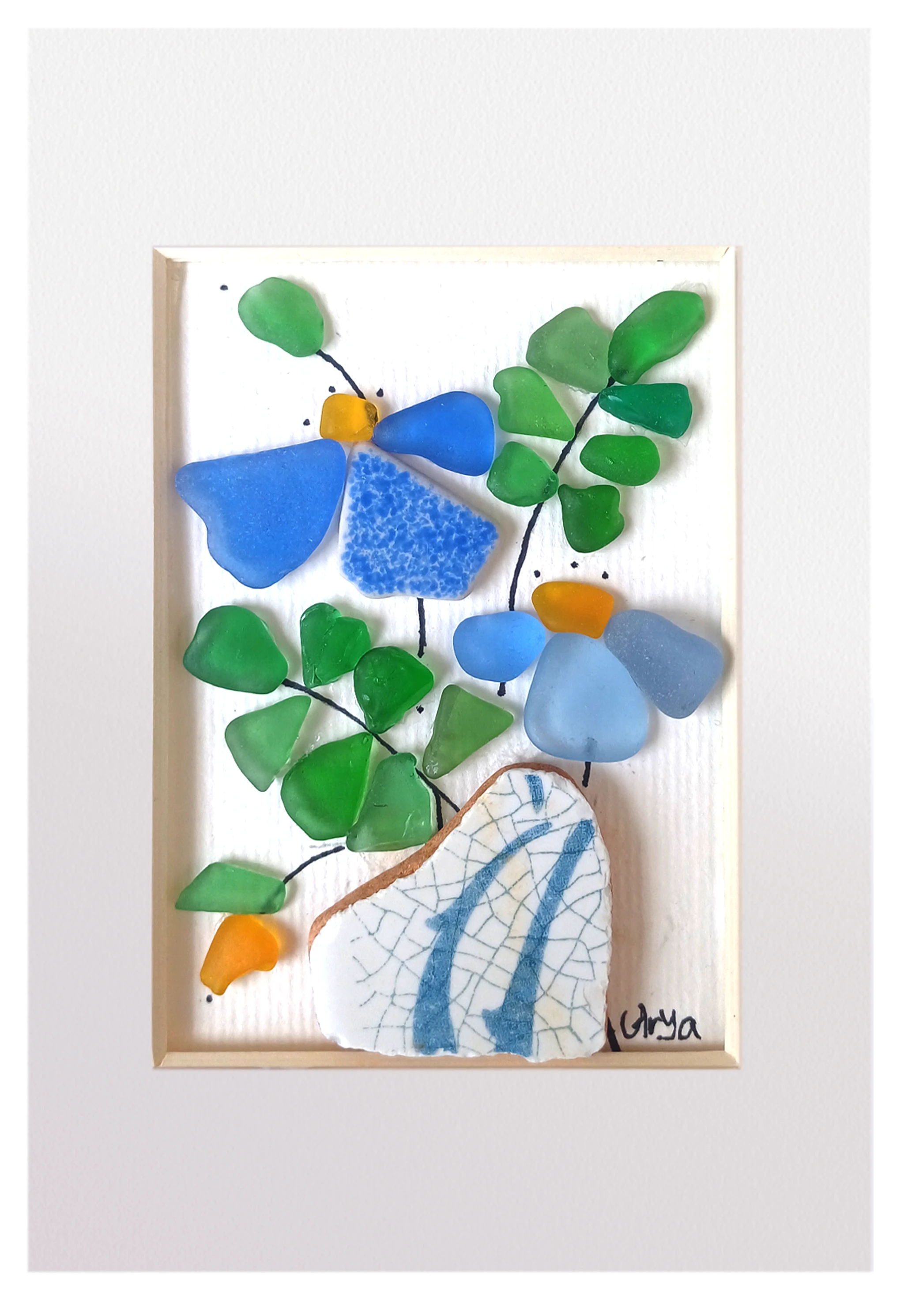 Cuadro con maceta de fragmento de cerámica con flores azules de vidrio de mar. 