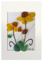 Cuadro de vidrio de mar y tinta con una planta con flores amarillas de centro marrón y hojas verdes